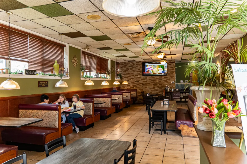 Dining room with booths, tables, hanging plants, and pendant lights